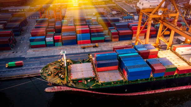 istock Logistics and transportation of Container Cargo ship and Cargo plane with working crane bridge in shipyard at sunset, logistic import export and transport industry background 1152114290