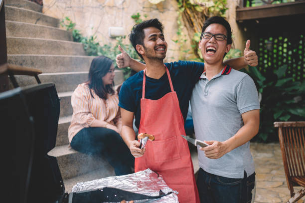 un groupe d’asiatiques multi-éthiques jeunes adultes rassemblement à la villa pendant le week-end pour la pause de la ville appréciant séance barbecue - asian cuisine photos photos et images de collection