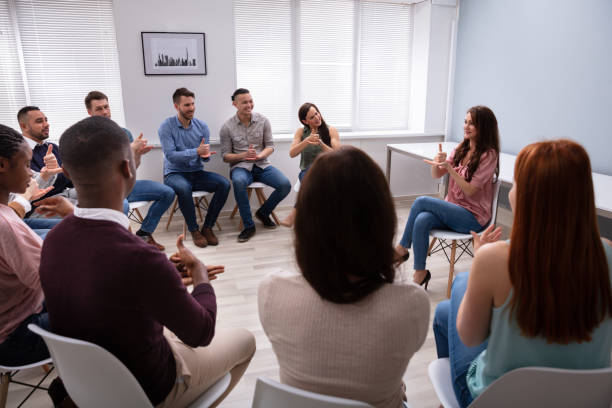 istock Woman Teaching Deaf Gesture Sign To Young Group 1152125088