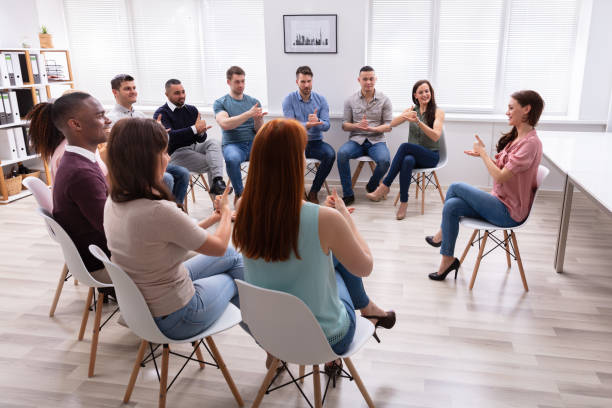 istock Woman Teaching Deaf Gesture Sign To Young Group 1152125090