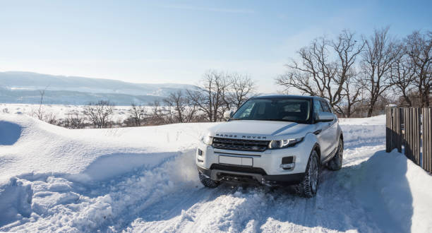 White Range Rover Evoque with a black roof on a winter road on the background of Zhiguli mountains of Samara region, Russia. Clear Sunny day 9 February 2019 White Range Rover Evoque with a black roof on a winter road on the background of Zhiguli mountains of Samara region, Russia. Clear Sunny day 9 February 2019. evoque stock pictures, royalty-free photos & images