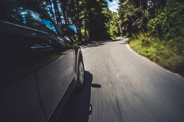istock Black car riding through the forest in the mountains 1152129519