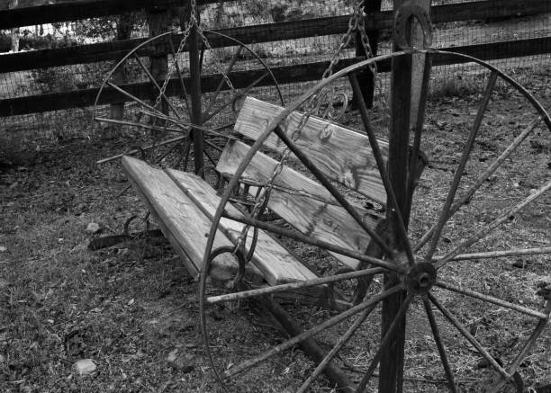 Black and White Wagon Wheel Bench Black and white image of an old-fashioned wagon wheel bench wagon wheel bench stock pictures, royalty-free photos & images