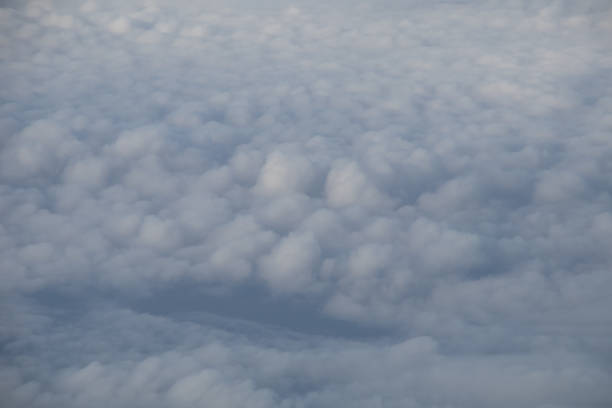 istock Aerial view from plane window with blue sky and white clouds 1152131511
