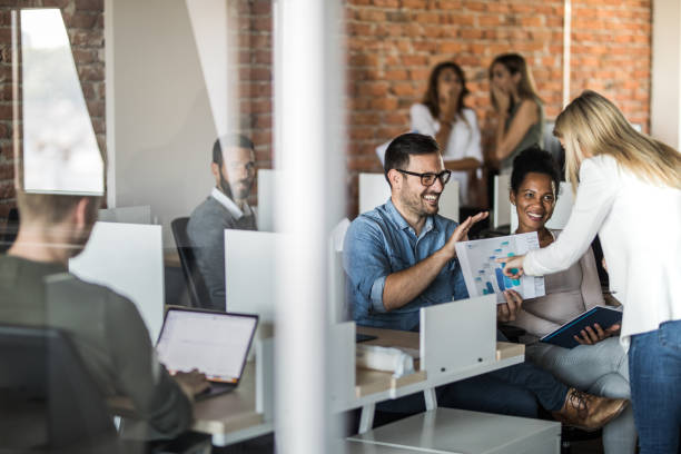 istock Happy business colleagues cooperating while analyzing reports at corporate office. 1152134722
