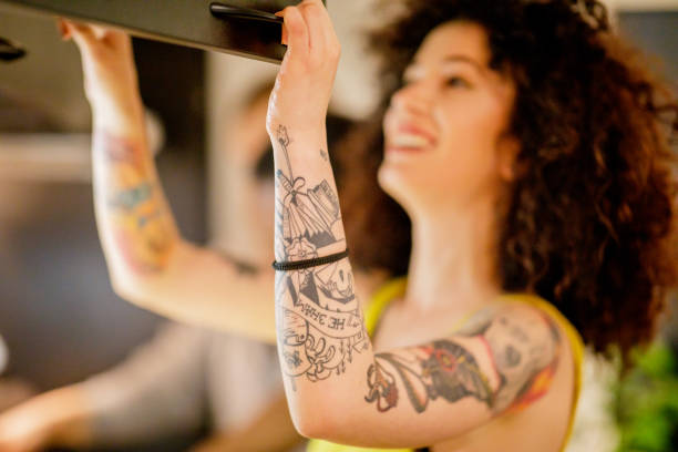 tattooed arm of a curly young woman smiling - 3498 imagens e fotografias de stock