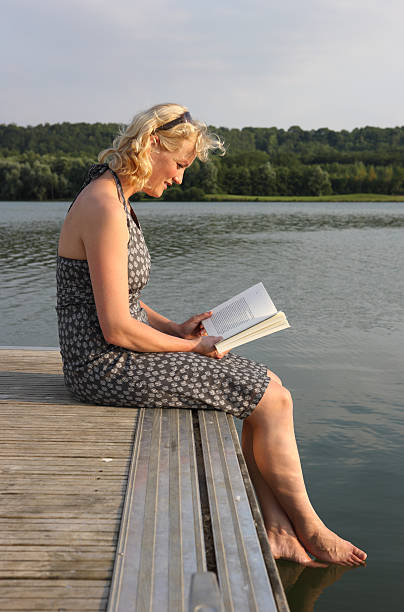 istock Young Woman On Jetty Reading A Book 115213939