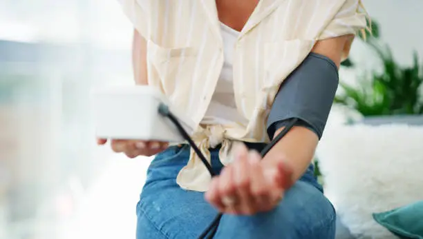 Cropped shot of a woman checking her blood pressure at home