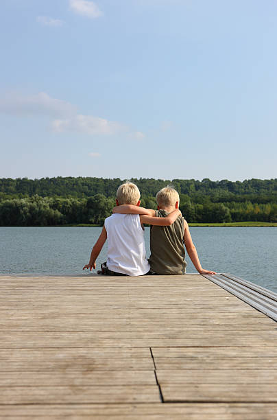 istock Young Friends Sitting At Jetty 115214322
