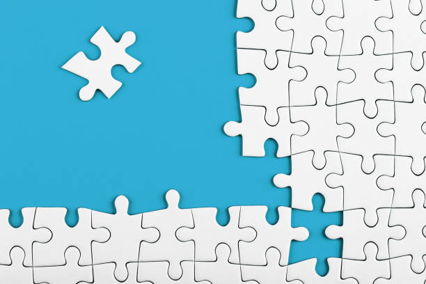 istock Unfinished white puzzle pieces on blue background 1152144072
