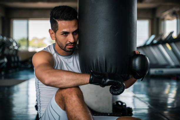 istock Boxer training on a punching bag in the gym 1152144526