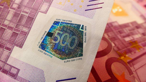 vue rapprochée d’un billet de banque de 500 euros avec sceau de sécurité et plusieurs 500 billets en euros en arrière-plan - five euro banknote european union currency number 5 paper currency photos et images de collection