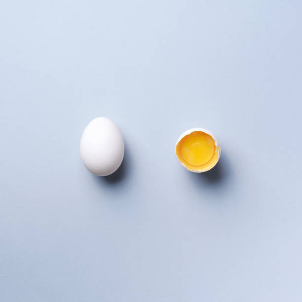 istock Food concept with broken egg and whole one on grey background. Top view. Creative pattern in minimal style. Flat lay. Square crop 1152145681