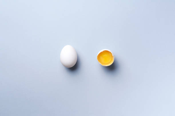 istock Food concept with broken egg and whole one on grey background. Top view. Creative pattern in minimal style. Flat lay 1152145712