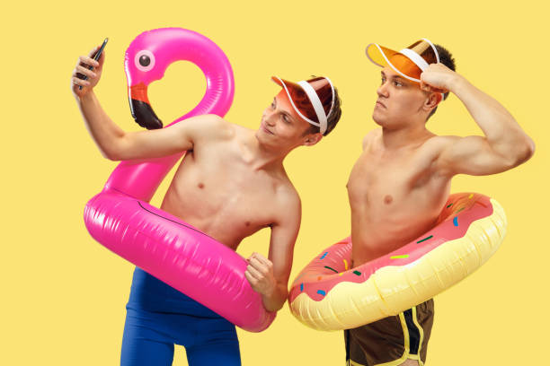 Two young men isolated on yellow studio background