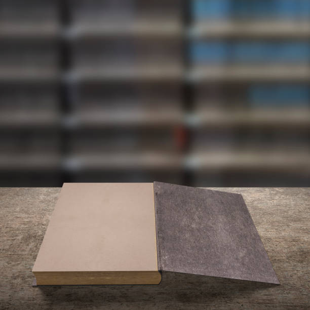 istock Old book on wooden table with blur bookshelfs background. 1152150703