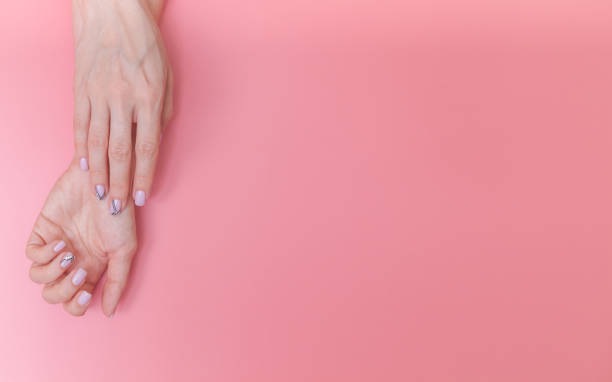 istock Beautiful, gentle female hands on a pink background with space for text. 1152153446