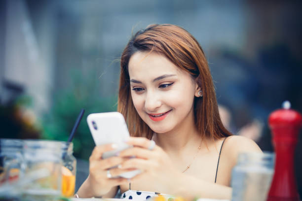 istock Happy young woman using phone at cafe 1152154652