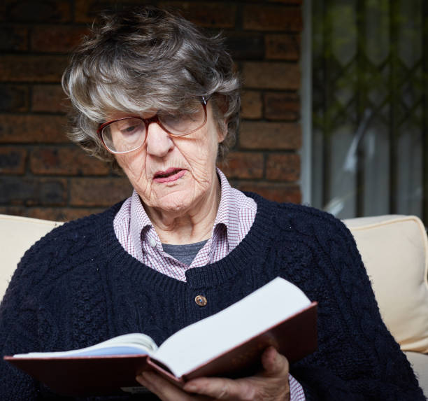istock Senior woman studies her Bible while sitting outdoors 1152157991