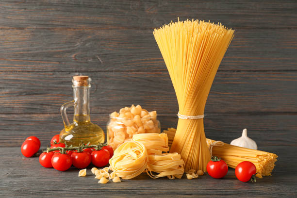 istock Composition with pasta, olive oil, tomatoes and garlic on wooden table, space for text 1152158602