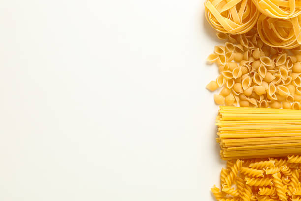 istock Different pasta on white background, space for text. Dry uncooked whole pasta 1152158649