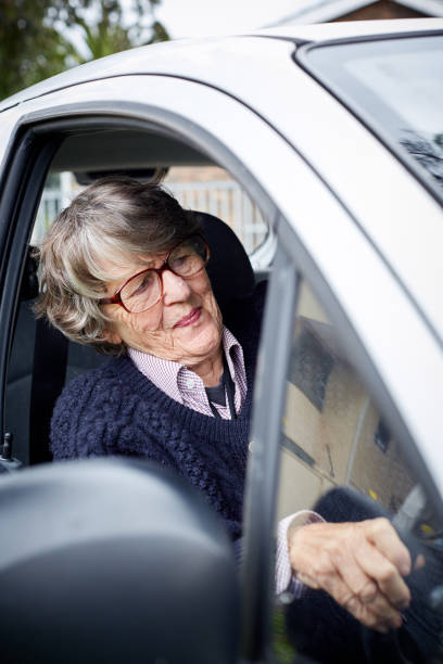 istock Smiling senior woman driving her car 1152158843