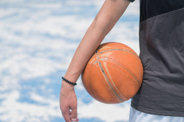 Outdoor basketball hoop with red rim and net full of fresh white snow in cold weather