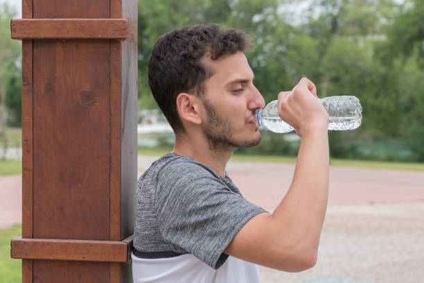istock Young man is enjoying beverage in park 1152159540