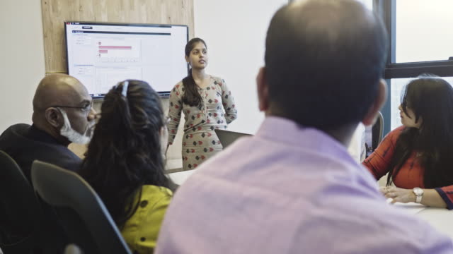 Indian businesswoman explaining to colleagues in meeting