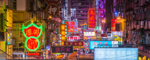 Hong Kong neon signs illuminated above Kowloon streets panorama China Elevated panoramic view across the vibrant neon signs and busy city streets of Kowloon at night, Hong Kong, China. mong kok stock pictures, royalty-free photos & images