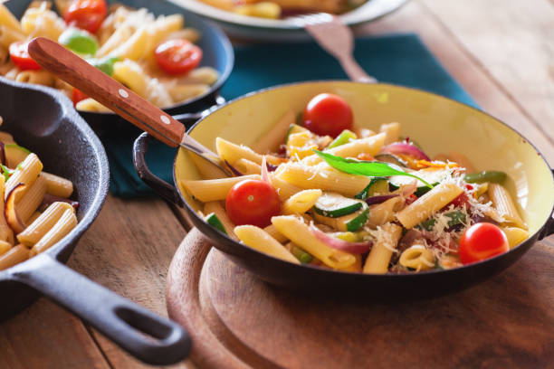 istock Penne pasta with vegetables and parmesan cheese, close-up 1152168224