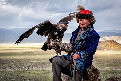 Eagle Hunter with his golden eagle in Bayan-Olgii, West Mongolia. Hunting with eagles is a traditional form of falconry found throughout the Eurasian Steppe.