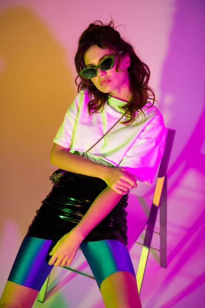 istock stylish redhead girl in sunglasses looking at camera while sitting on purple with gradient 1152171154