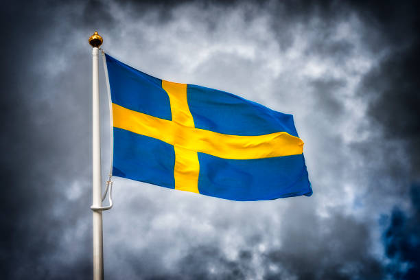 Swedish flag waving from a boat in the idyllic archipelago near gothenburg, sweden, during a sunny summer day