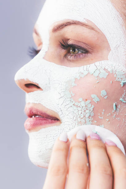 istock Girl removes dry white mud mask 1152172762