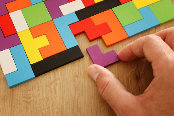 istock man's hand holding a square tangram puzzle, over wooden table 1152173593