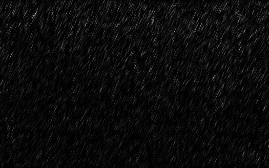 Falling raindrops isolated on dark background. Heavy rain and weather storm in raining season.