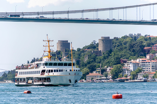 Passenger ship under Fatih sultan mehmet FSM bridge at bosphorus in istanbul turkey