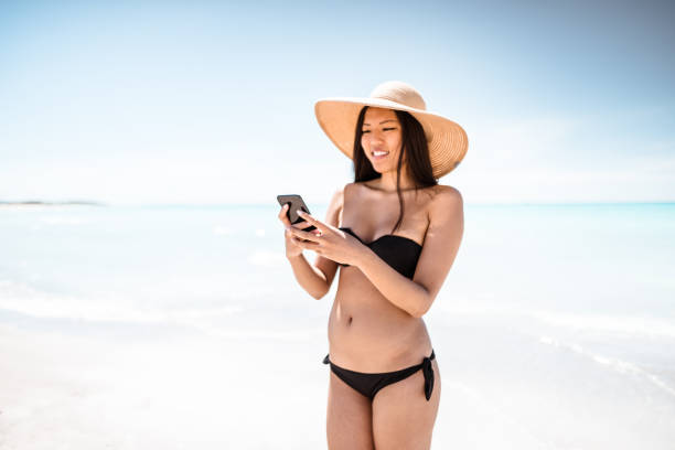 istock on the phone at summer on the beach 1152177866