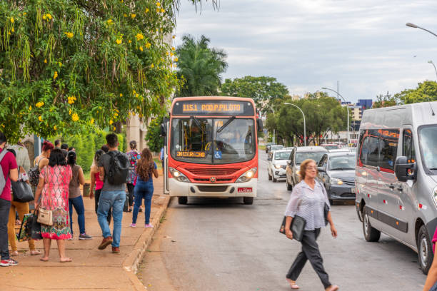 People waiting at bus stop in Brasilia city centre with a bus approaching
