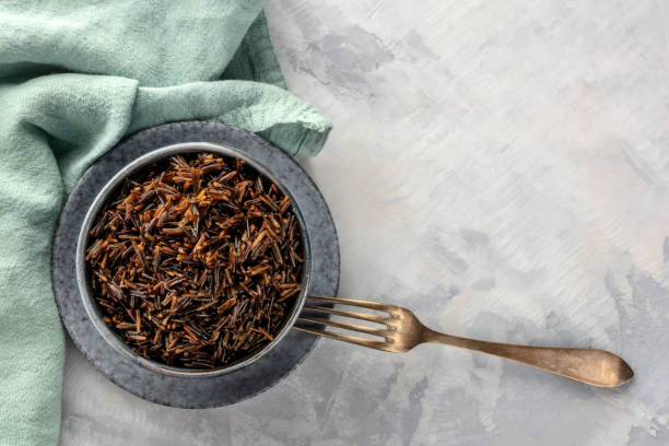 istock Wild black rice, shot from above with a fork and copy space, on teal and grey textures 1152178248