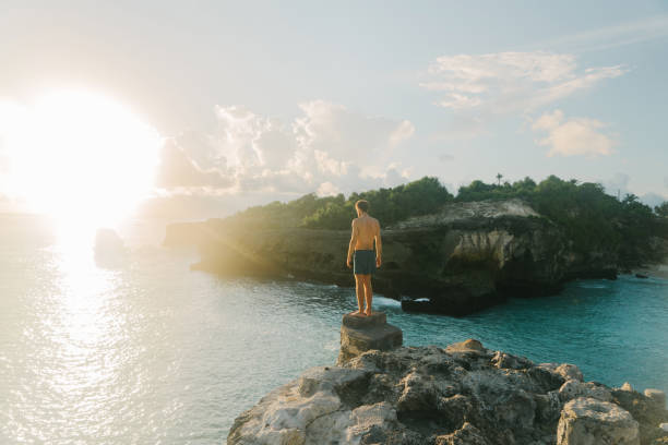 homme sautant de la falaise dans le lagon bleu sur nusa ceningan - nusa lembongan photos photos et images de collection