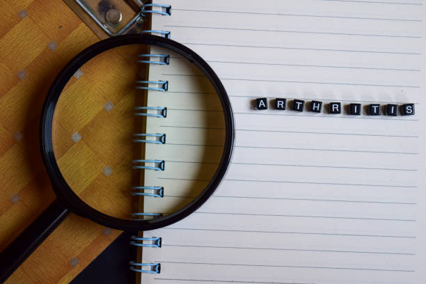 istock arthritis on wooden block and magnifying glass. Motivation concept 1152184294
