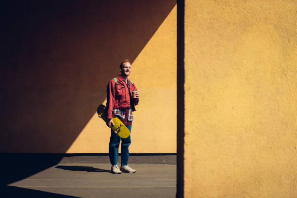 istock Smiling hipster man with skateboard and coffee 1152185365