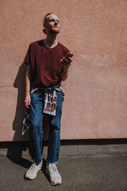 istock Young smiling hipster man with mobile phone 1152185437