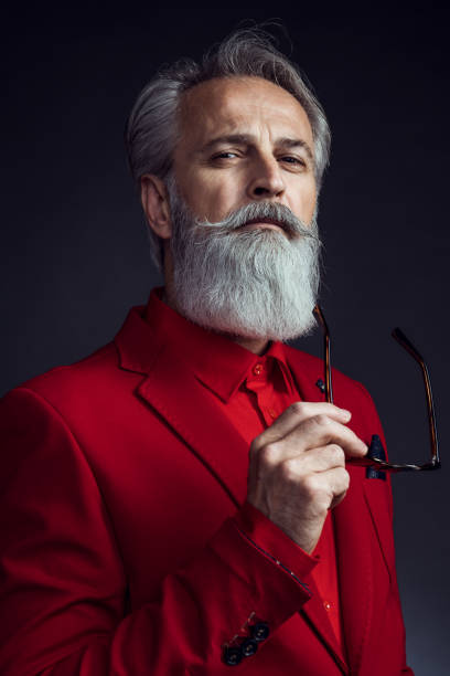 Happy well dressed gentleman having photoshooting in studio Portrait of senior man wearing red jacket on dark background. Styled, well dressed man. luxury eyewear stock pictures, royalty-free photos & images