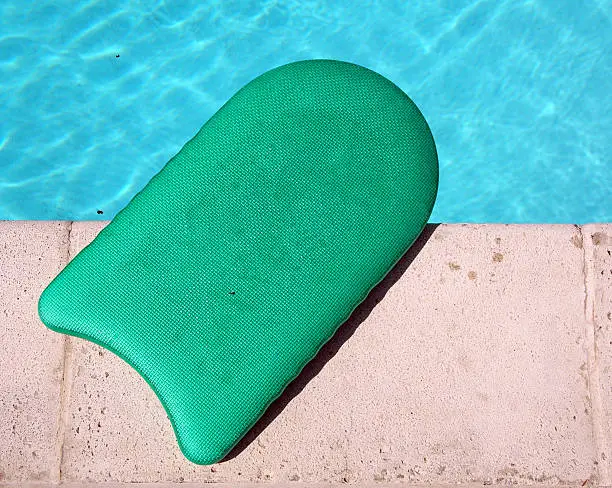 Green kickboard on the side of the swimming pool
