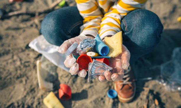 Child hands with garbage from the beach stock photo
