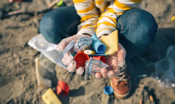 Photo of Child hands with garbage from the beach