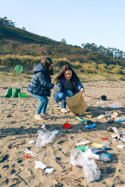 istock Female volunteers cleaning the beach 1152189905
